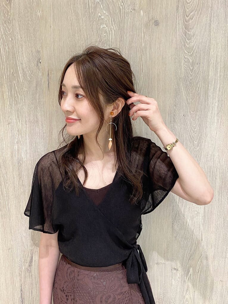 ホワイト系のハンドバッグ、ブラウン系のスカート、ブラウン系のニット/セーターを着用したレディースの夏コーディネートの6枚目の写真