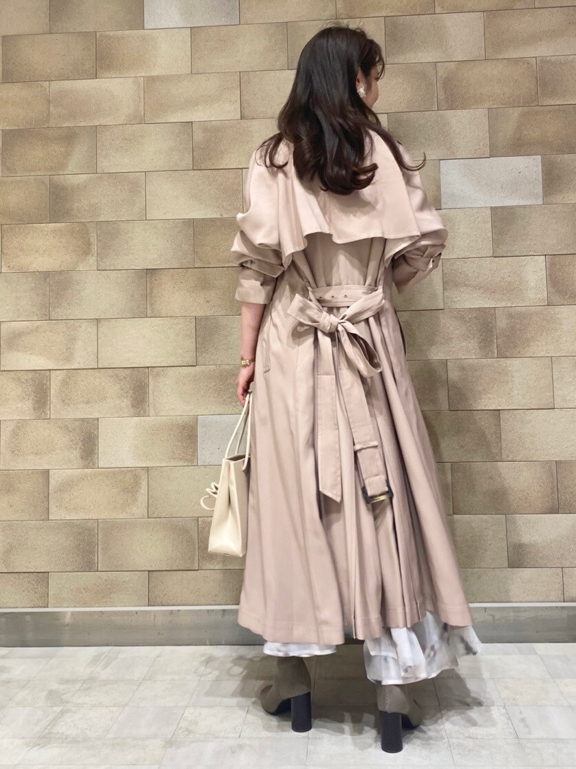 ベージュ系のトレンチコート、ベージュ系のトートバッグ、ホワイト系のニット/セーターを着用したレディースの冬コーディネートの8枚目の写真