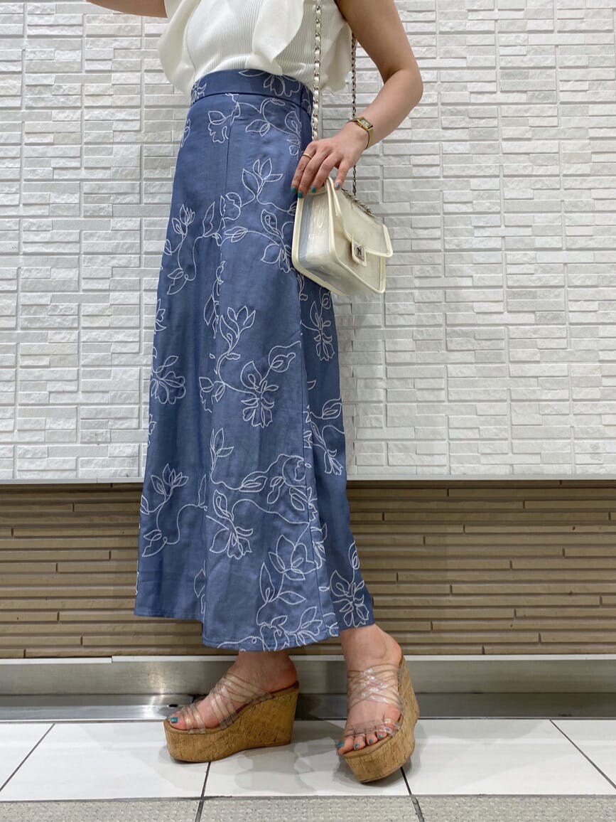 ホワイト系のショルダーバッグ、ブルー系のスカート、ホワイト系のニット/セーターを着用したレディースの夏コーディネートの3枚目の写真