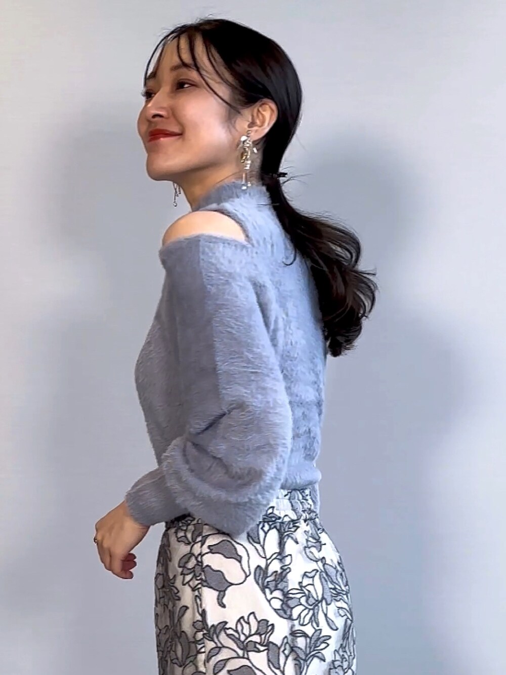 ブルー系のニット/セーター、グレー系のスカート、ブラウン系のブーツを着用したレディースの秋コーディネートの4枚目の写真