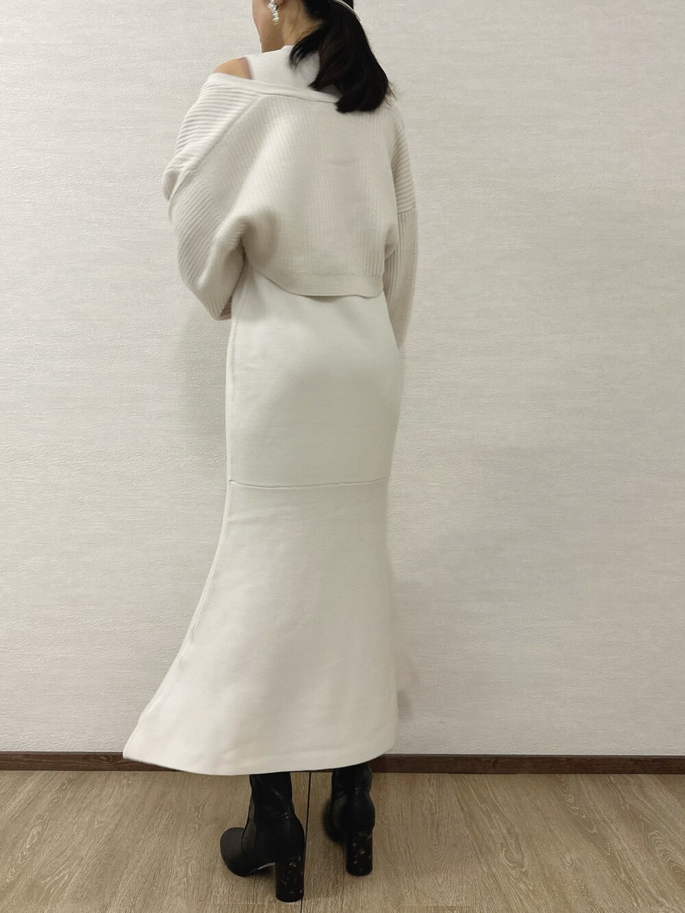 ホワイト系のワンピース、シルバー系のハンドバッグ、ブラック系のブーツを着用したレディースの秋コーディネートの4枚目の写真