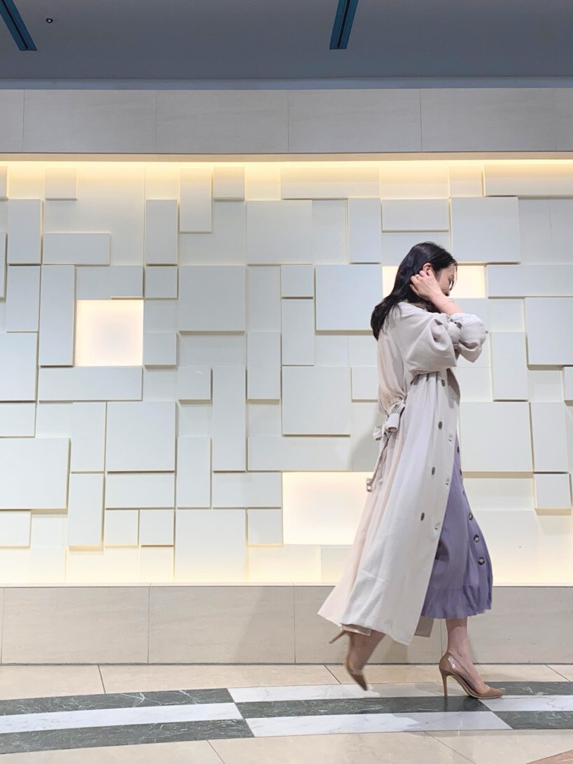 ベージュ系のパンプス、ベージュ系のトレンチコート、パープル系のワンピースを着用したレディースの春コーディネートの6枚目の写真