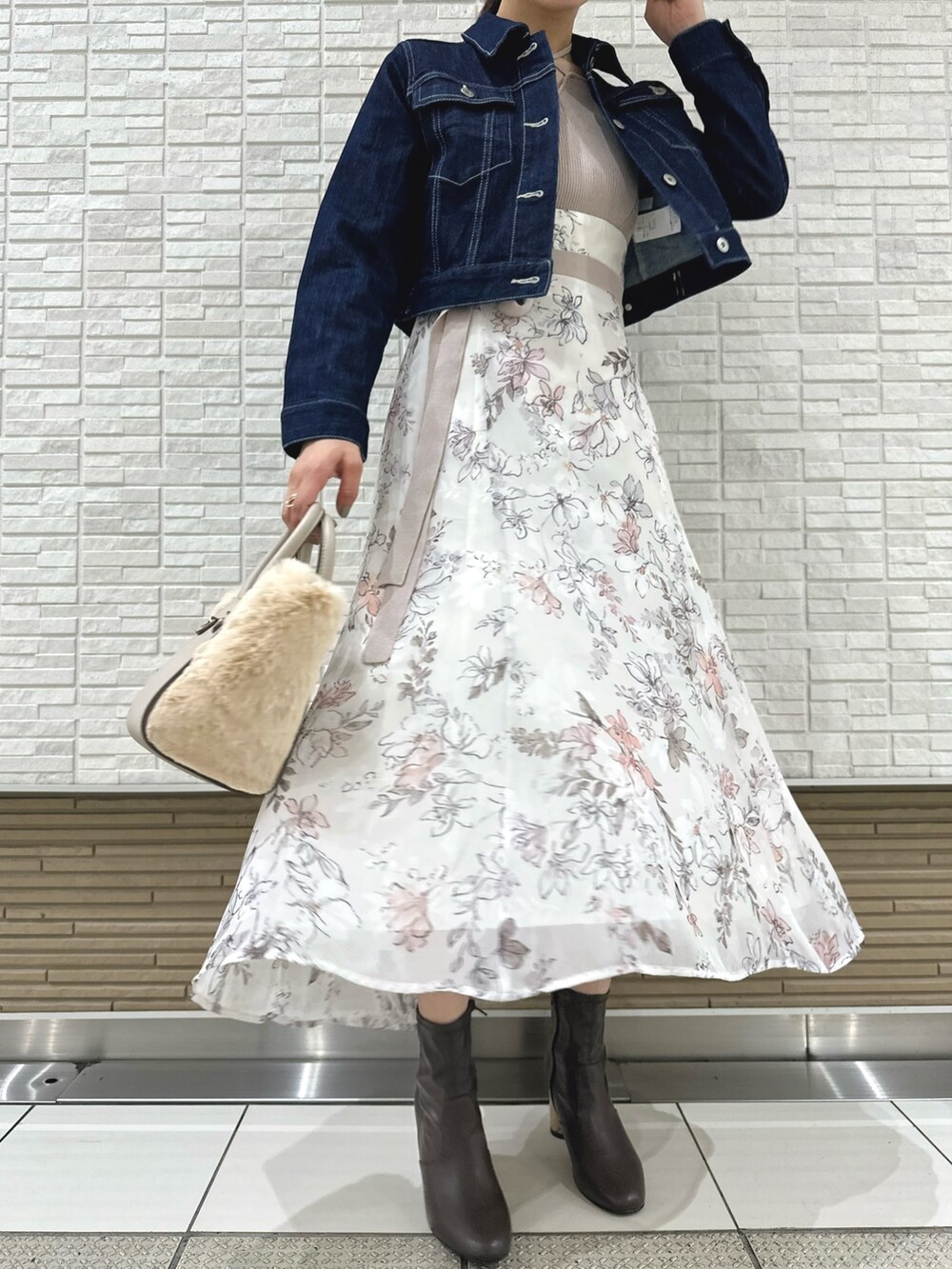 ブラウン系のブーツ、ホワイト系のハンドバッグ、ブルー系のデニムジャケットを着用したレディースの夏コーディネートの8枚目の写真