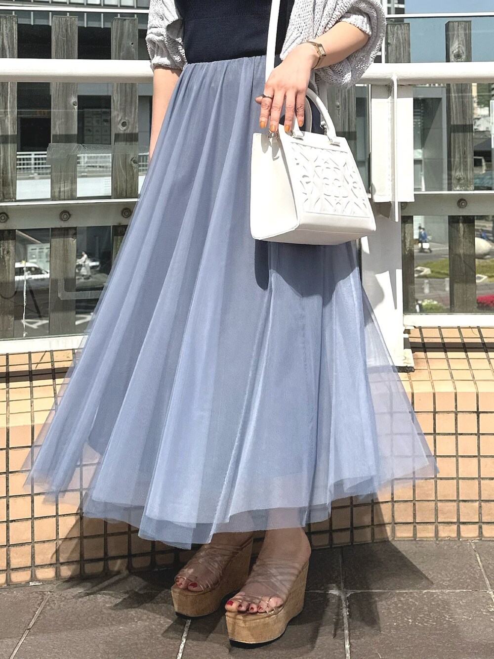 グレー系のカーディガン/ボレロ、ホワイト系のショルダーバッグ、ブルー系のワンピースを着用したレディースの春コーディネートの7枚目の写真