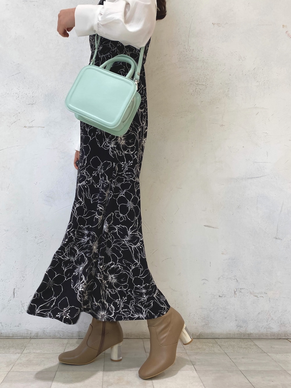 ベージュ系のブーツ、グリーン系のハンドバッグ、その他のワンピースを着用したレディースの冬コーディネートの9枚目の写真