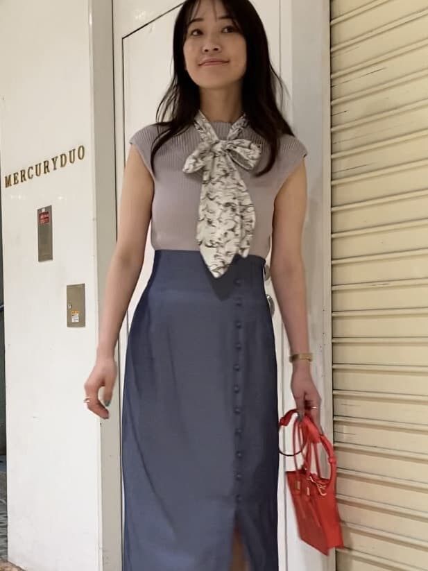 レッド系のハンドバッグ、その他のサンダル、ブルー系のスカートを着用したレディースの夏コーディネートの2枚目の写真