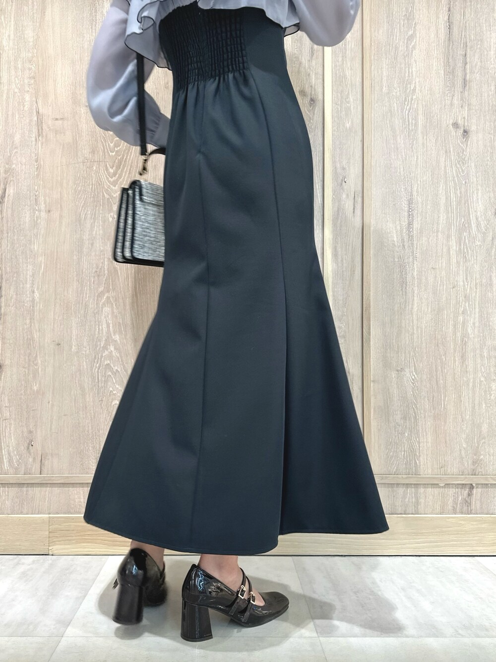 ブラック系のショルダーバッグ、グレー系のワンピース、ブラウン系のパンプスを着用したレディースの冬コーディネートの10枚目の写真