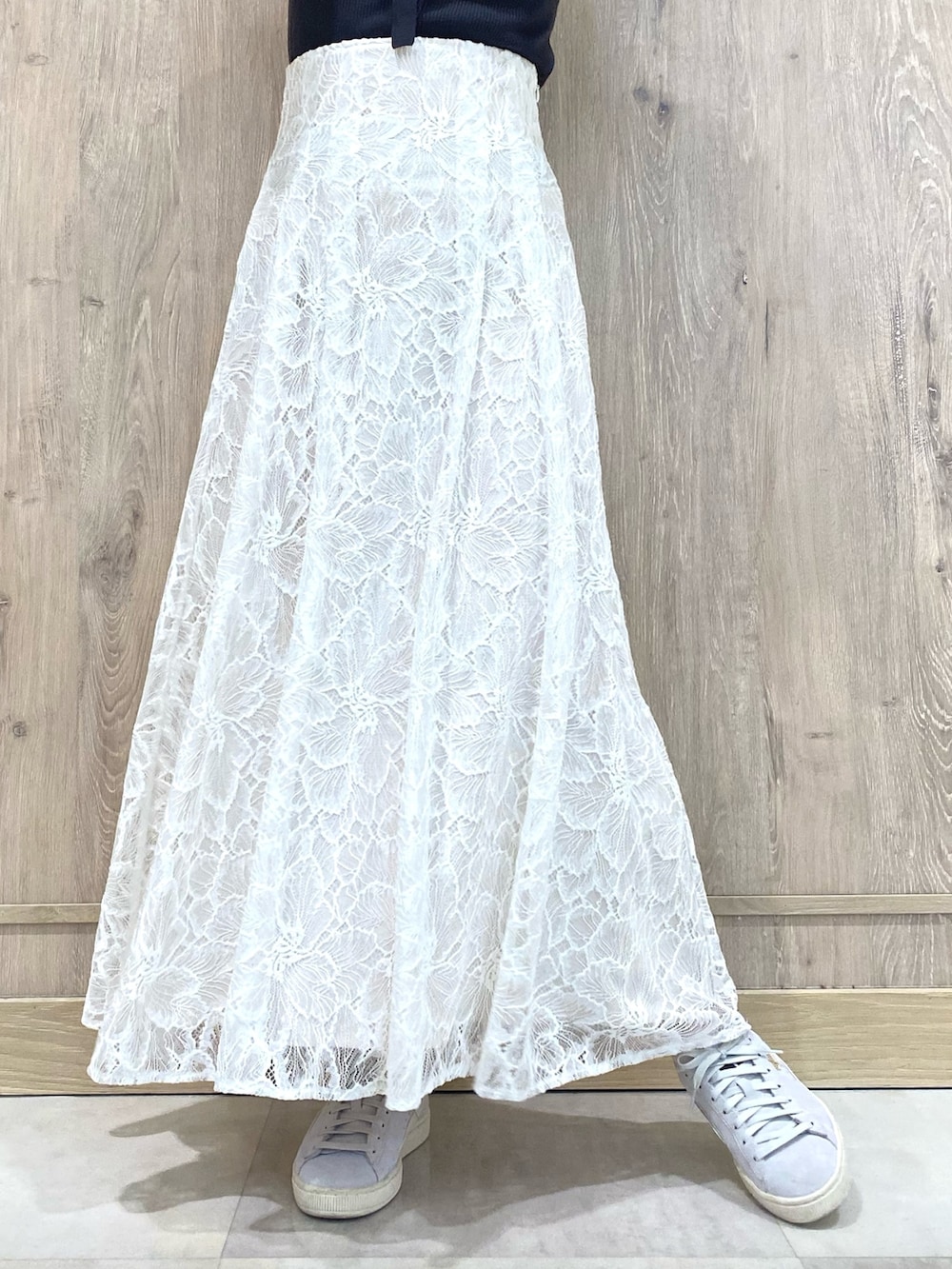 グレー系のスニーカー、ホワイト系のスカート、グレー系のニット/セーターを着用したレディースの冬コーディネートの7枚目の写真