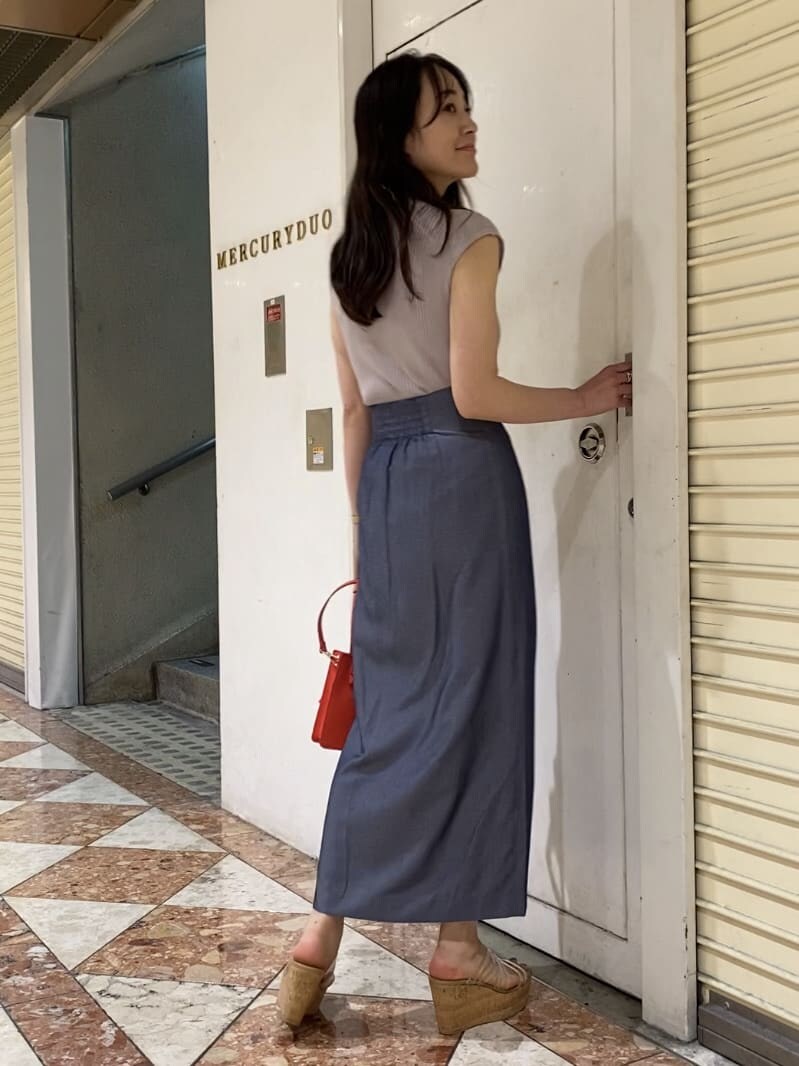 レッド系のハンドバッグ、その他のサンダル、ブルー系のスカートを着用したレディースの夏コーディネートの4枚目の写真