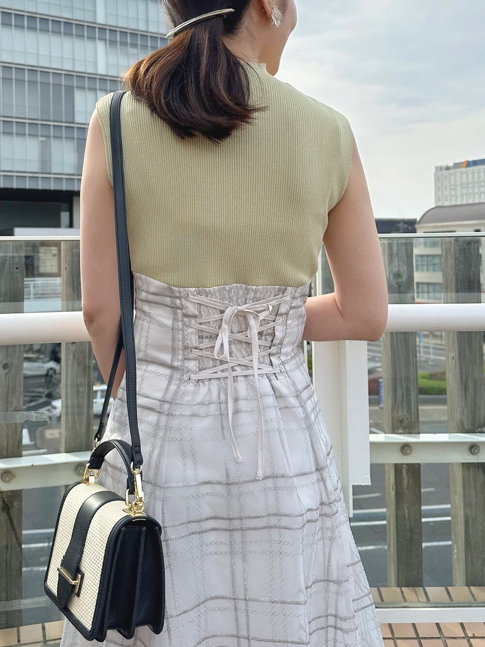 その他のサンダル、ブラック系のハンドバッグ、グリーン系のワンピースを着用したレディースの春コーディネートの6枚目の写真