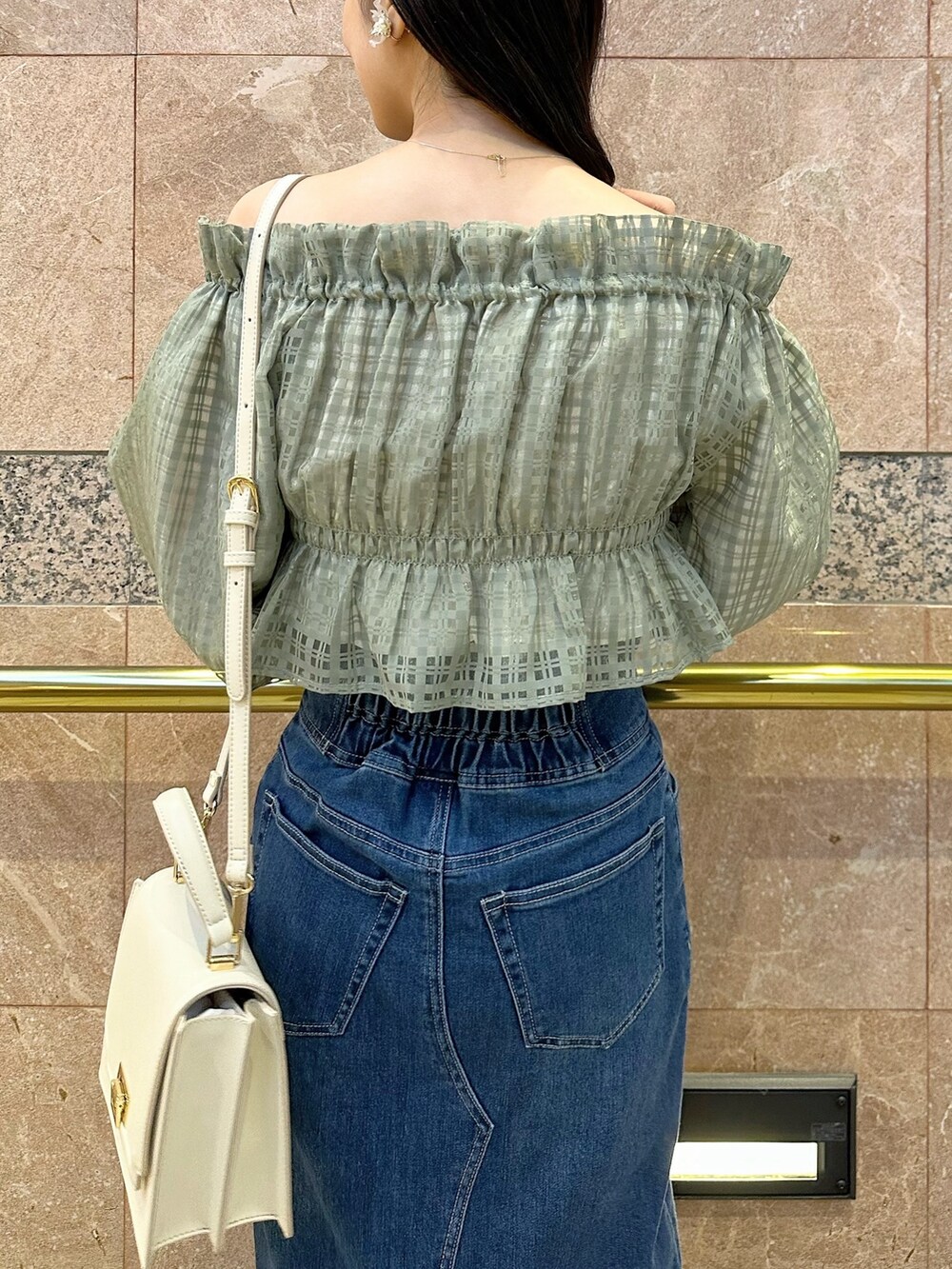 グリーン系のシャツ/ブラウス、ブルー系のデニムスカート、ベージュ系のパンプスを着用したレディースの冬コーディネートの7枚目の写真