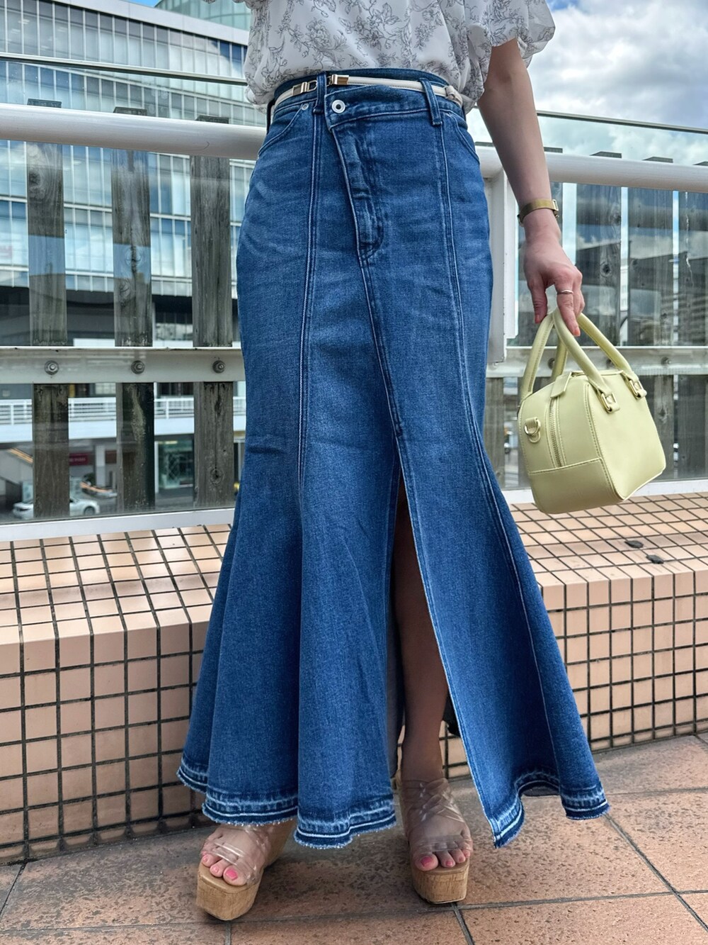 その他のサンダル、ブルー系のデニムスカート、グレー系のシャツ/ブラウスを着用したレディースの夏コーディネートの7枚目の写真