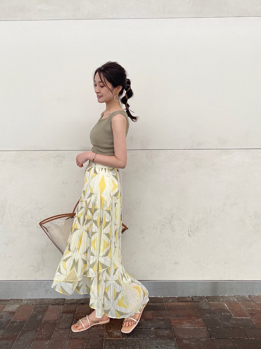 ブラウン系のトートバッグ、ベージュ系のサンダル、イエロー系のスカートを着用したレディースの夏コーディネートの2枚目の写真