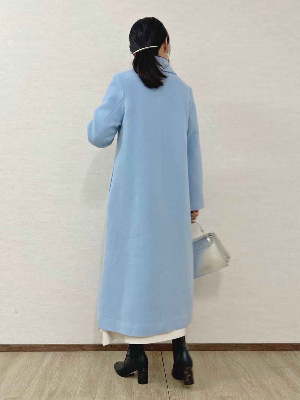 ブラック系のブーツ、シルバー系のハンドバッグ、ホワイト系のワンピースを着用したレディースの秋コーディネートの5枚目の写真