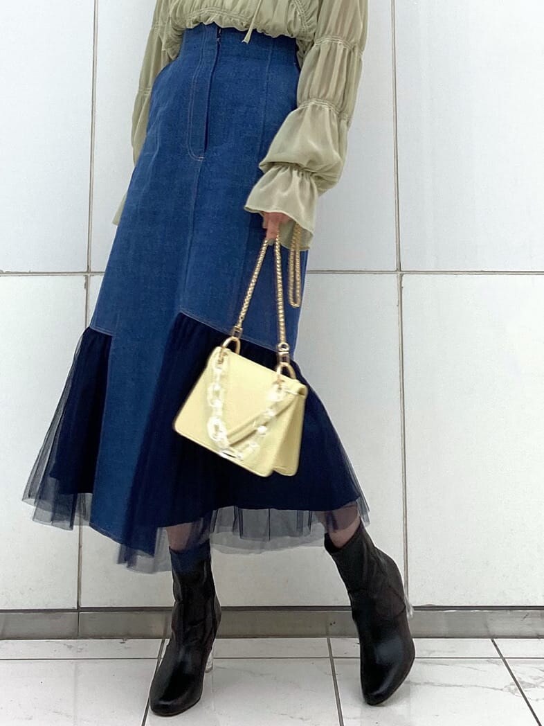 ホワイト系のTシャツ/カットソー、ブルー系のスカート、イエロー系のシャツ/ブラウスを着用したレディースの冬コーディネートの9枚目の写真