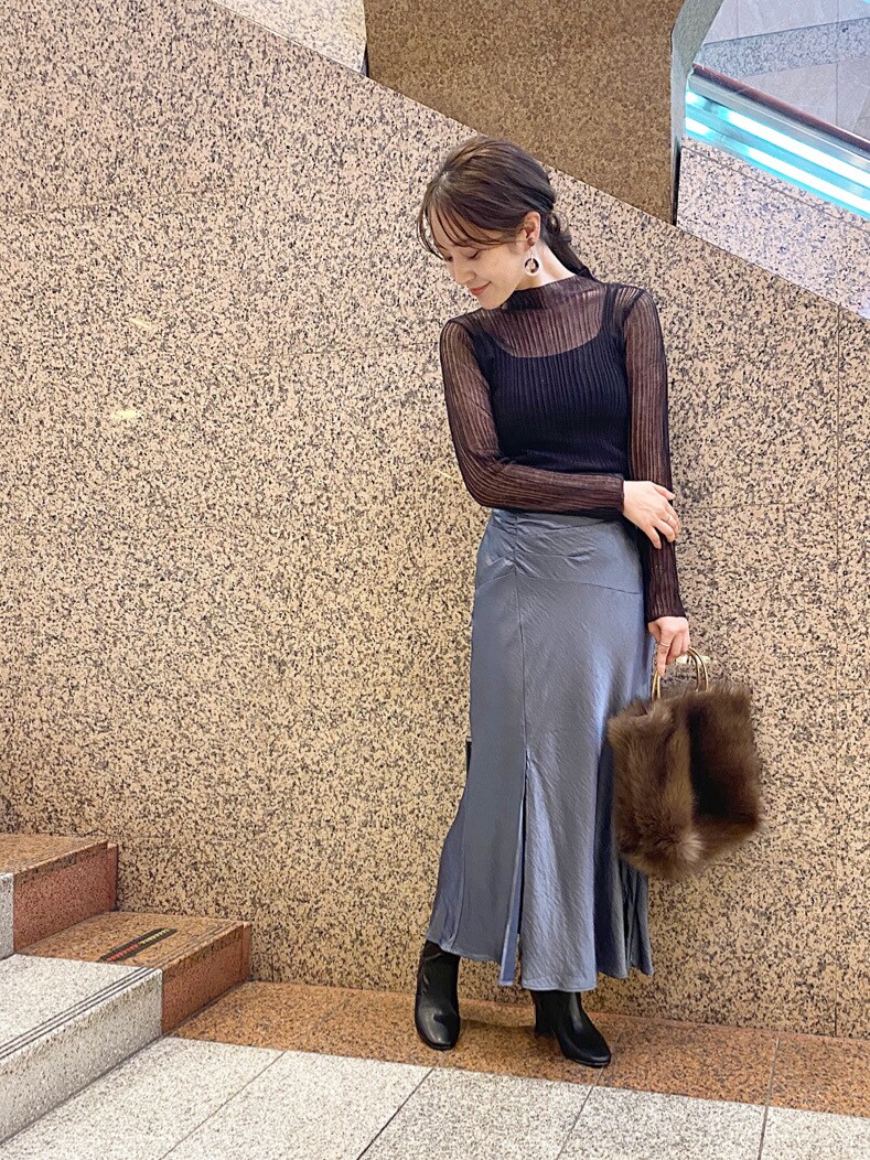 ブラック系のブーツ、ベージュ系のイヤリングを着用したレディースの秋コーディネートの2枚目の写真