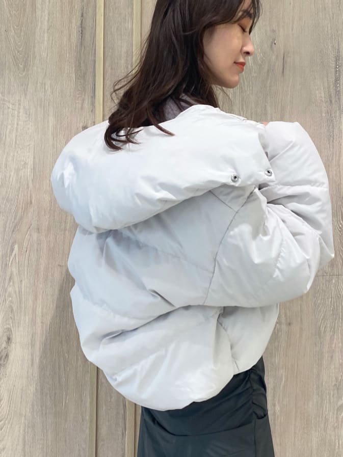 ホワイト系のダウンジャケット/コート、ブラック系のブーツ、パープル系のニット/セーターを着用したレディースの秋コーディネートの8枚目の写真