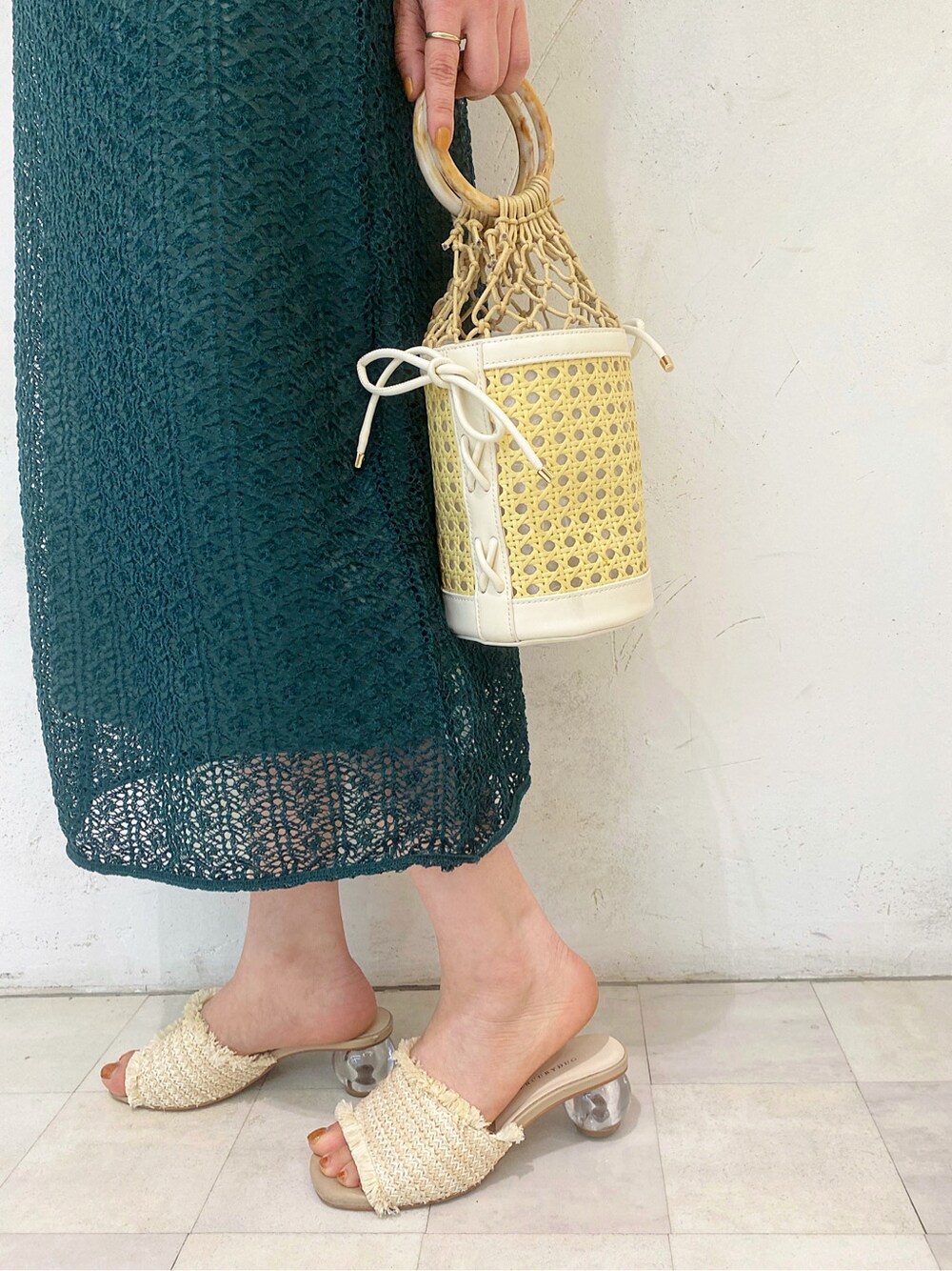 ホワイト系のサンダル、グリーン系のワンピース、ホワイト系のハンドバッグを着用したレディースの春コーディネートの6枚目の写真