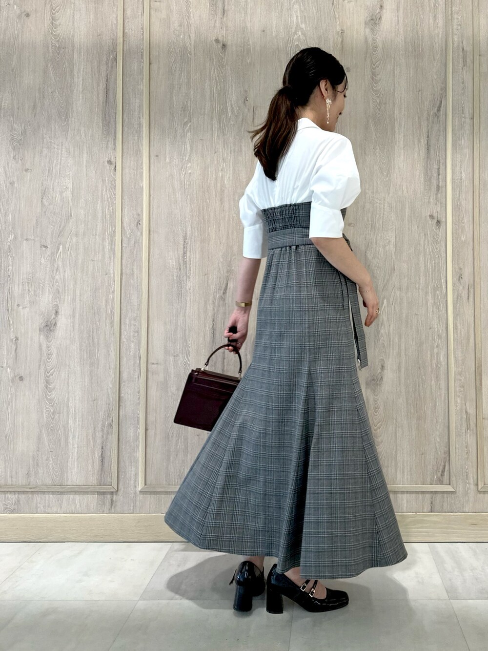 ブラウン系のパンプス、レッド系のハンドバッグ、その他のワンピースを着用したレディースの夏コーディネートの3枚目の写真