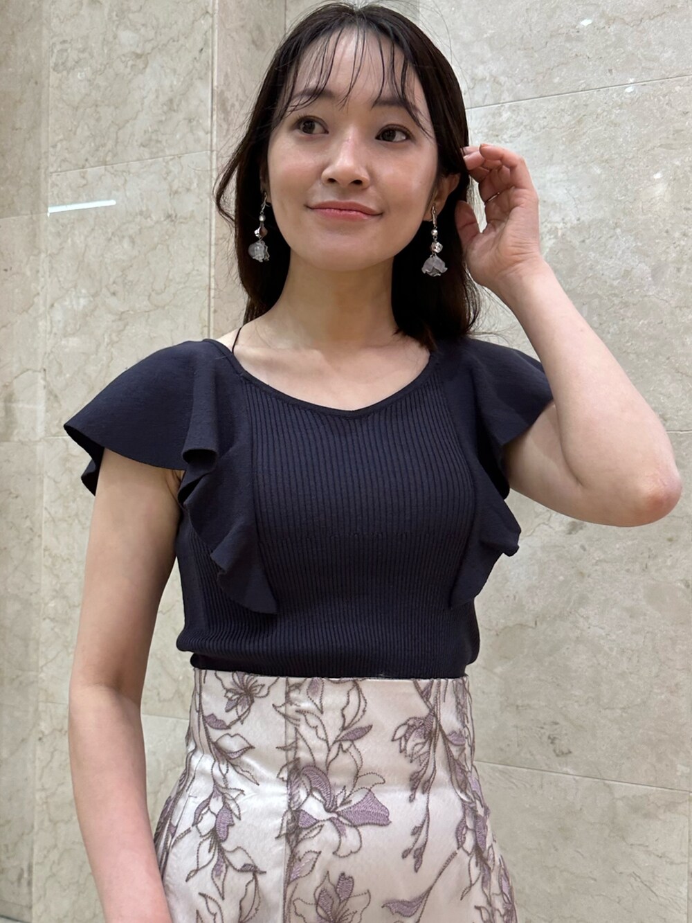 ブラック系のチューブトップ、ブラウン系のサンダル、ピンク系のスカートを着用したレディースの春コーディネートの4枚目の写真