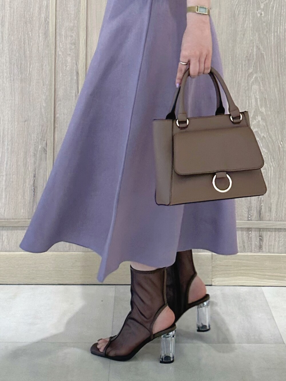 ブラウン系のハンドバッグ、ブラウン系のブーツ、パープル系のワンピースを着用したレディースの春コーディネートの9枚目の写真