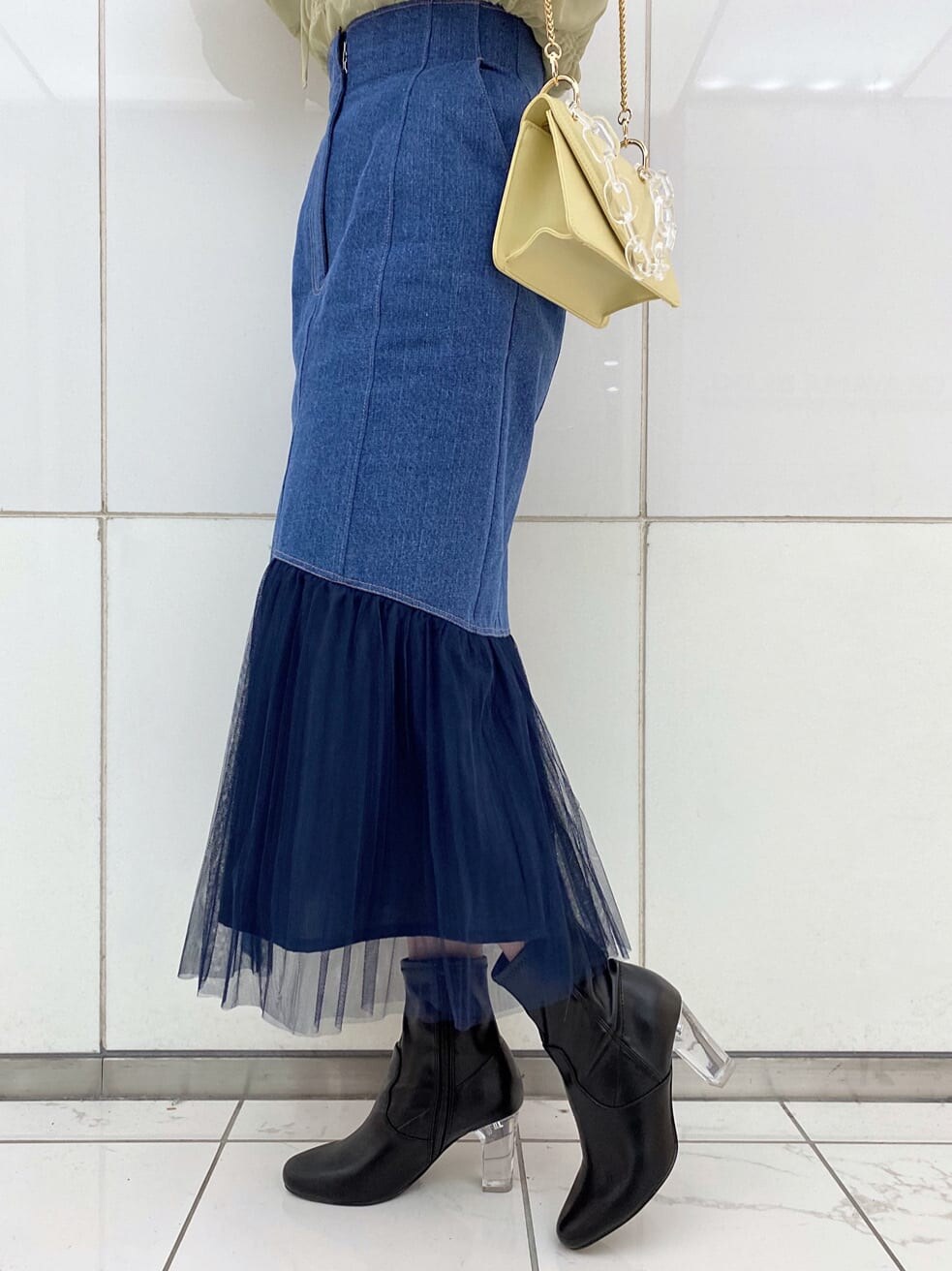 ホワイト系のTシャツ/カットソー、ブルー系のスカート、イエロー系のシャツ/ブラウスを着用したレディースの冬コーディネートの10枚目の写真