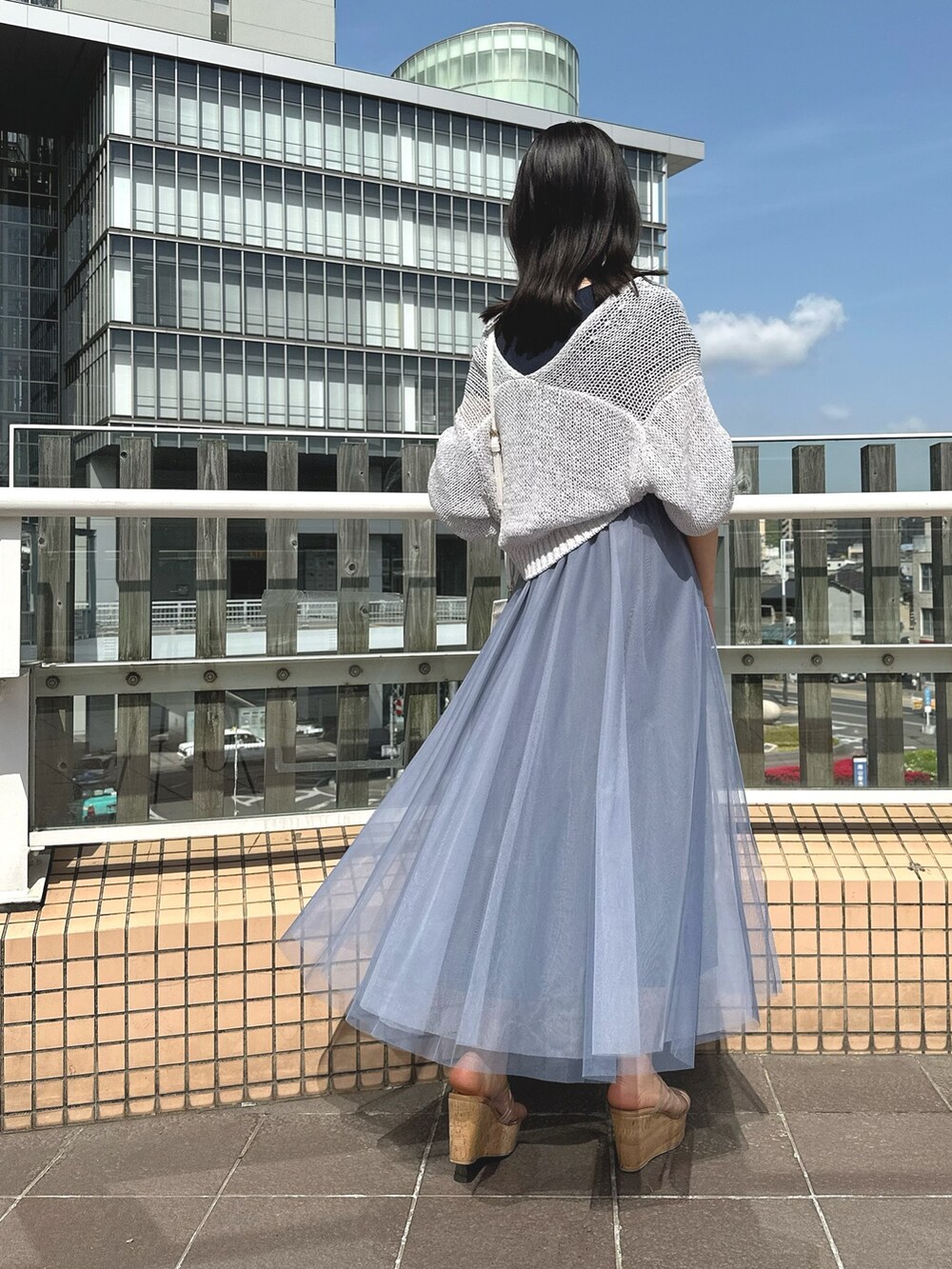 グレー系のカーディガン/ボレロ、ホワイト系のショルダーバッグ、ブルー系のワンピースを着用したレディースの春コーディネートの3枚目の写真