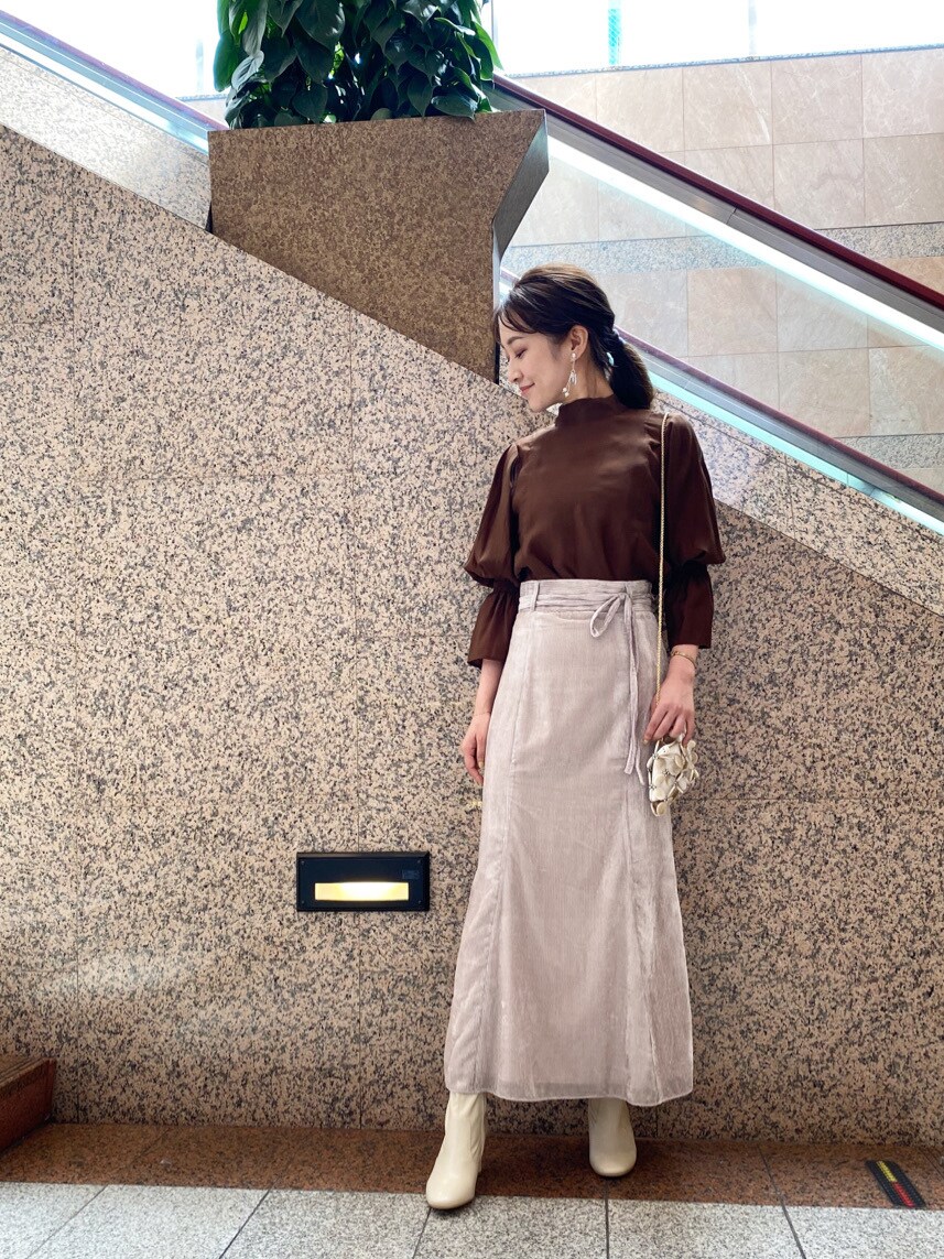 ブラウン系のシャツ/ブラウス、ベージュ系のスカート、ホワイト系のハンドバッグを着用したレディースの夏コーディネートの2枚目の写真