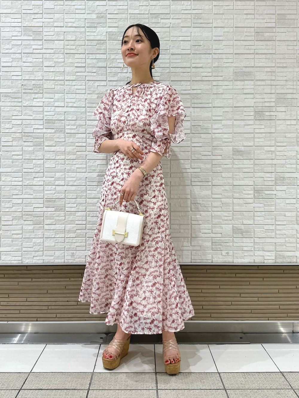 その他のサンダル、ピンク系のワンピース、ホワイト系のハンドバッグを着用したレディースの春コーディネートの2枚目の写真