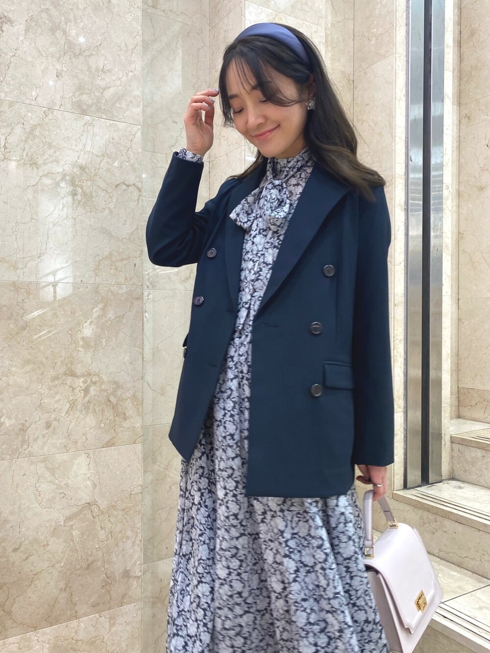 ブラック系のワンピース、ブラック系のブーツ、ブルー系のテーラードジャケットを着用したレディースの冬コーディネートの5枚目の写真