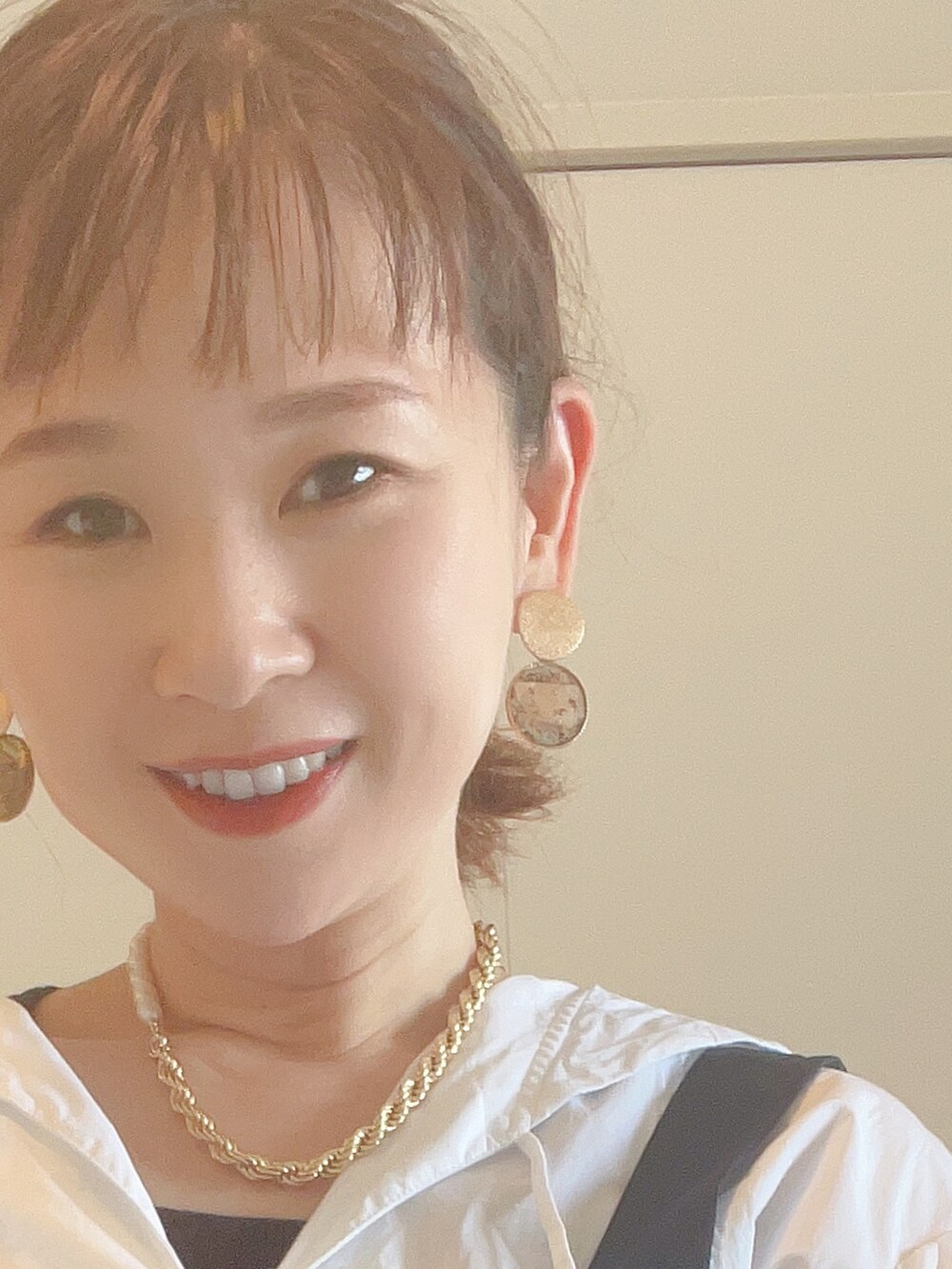 ブラック系のワンピース、ホワイト系のシャツ/ブラウス、ブラック系のサンダルを着用したレディースの春コーディネートの3枚目の写真