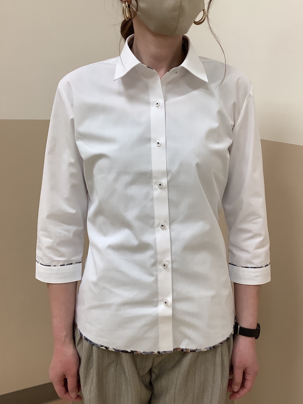 ホワイト系のビジネスシャツを着用したレディースの春コーディネートの2枚目の写真