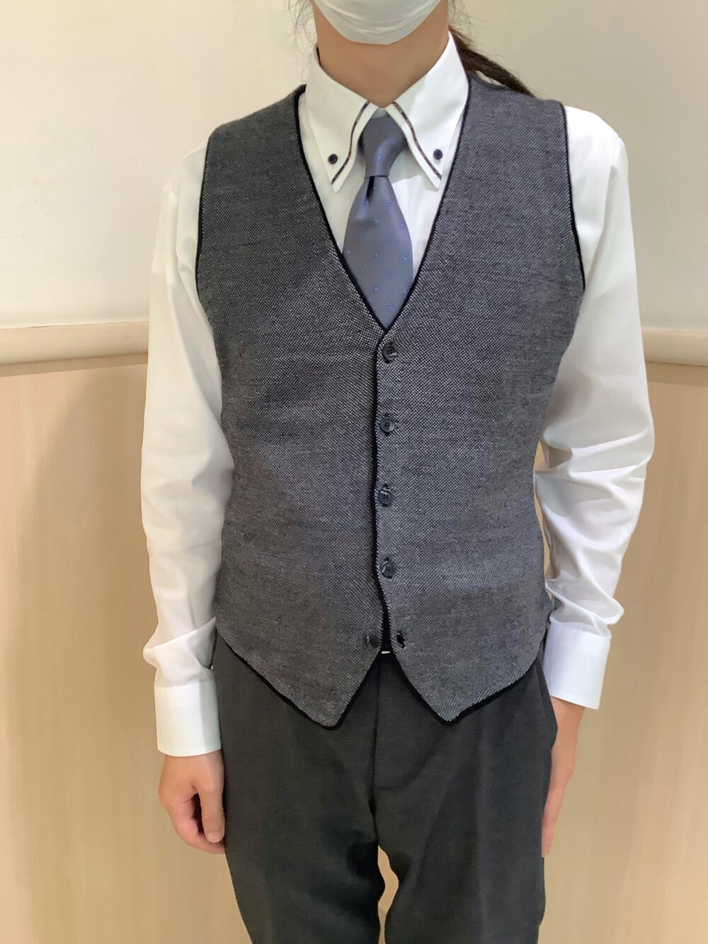 グレー系のベスト、グレー系のネクタイ、ホワイト系のビジネスシャツを着用したメンズの秋コーディネートの2枚目の写真
