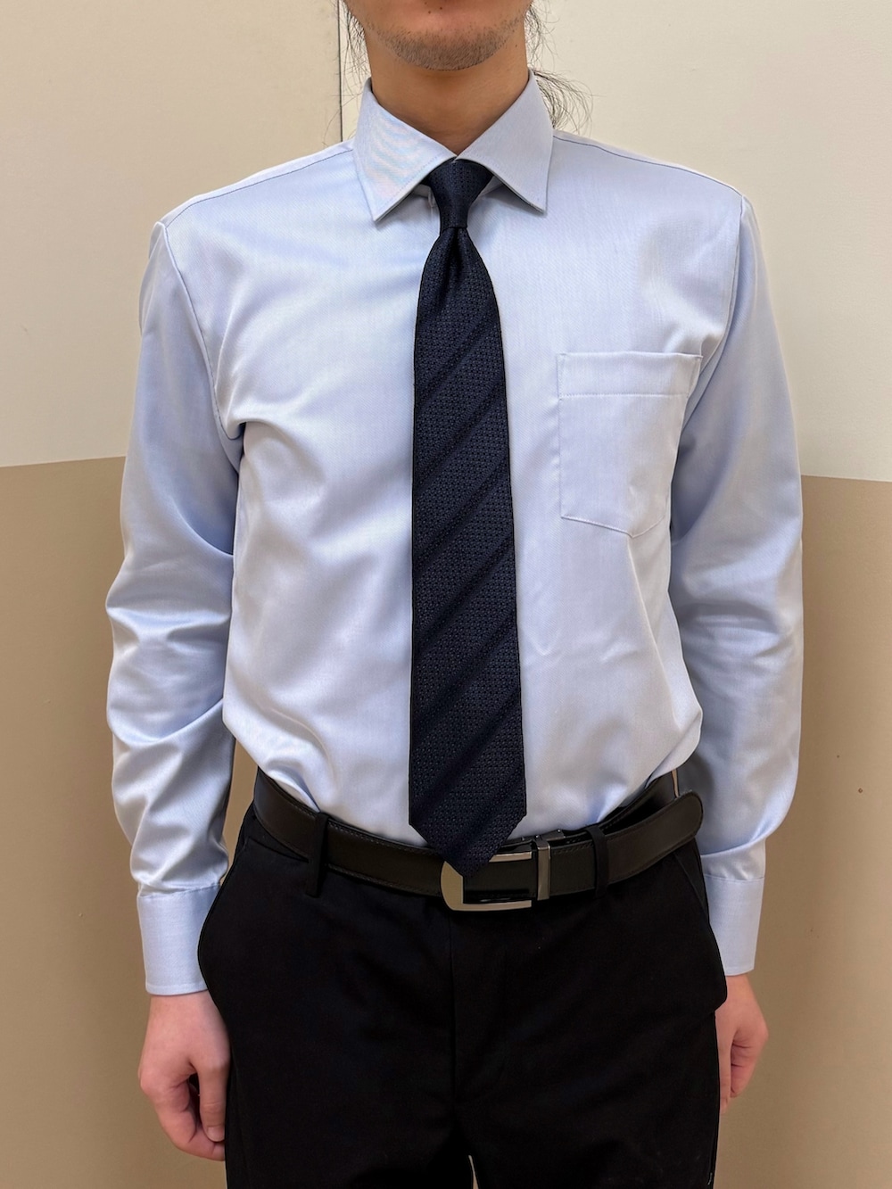 ブルー系のビジネスシャツを着用したメンズの冬コーディネートの2枚目の写真