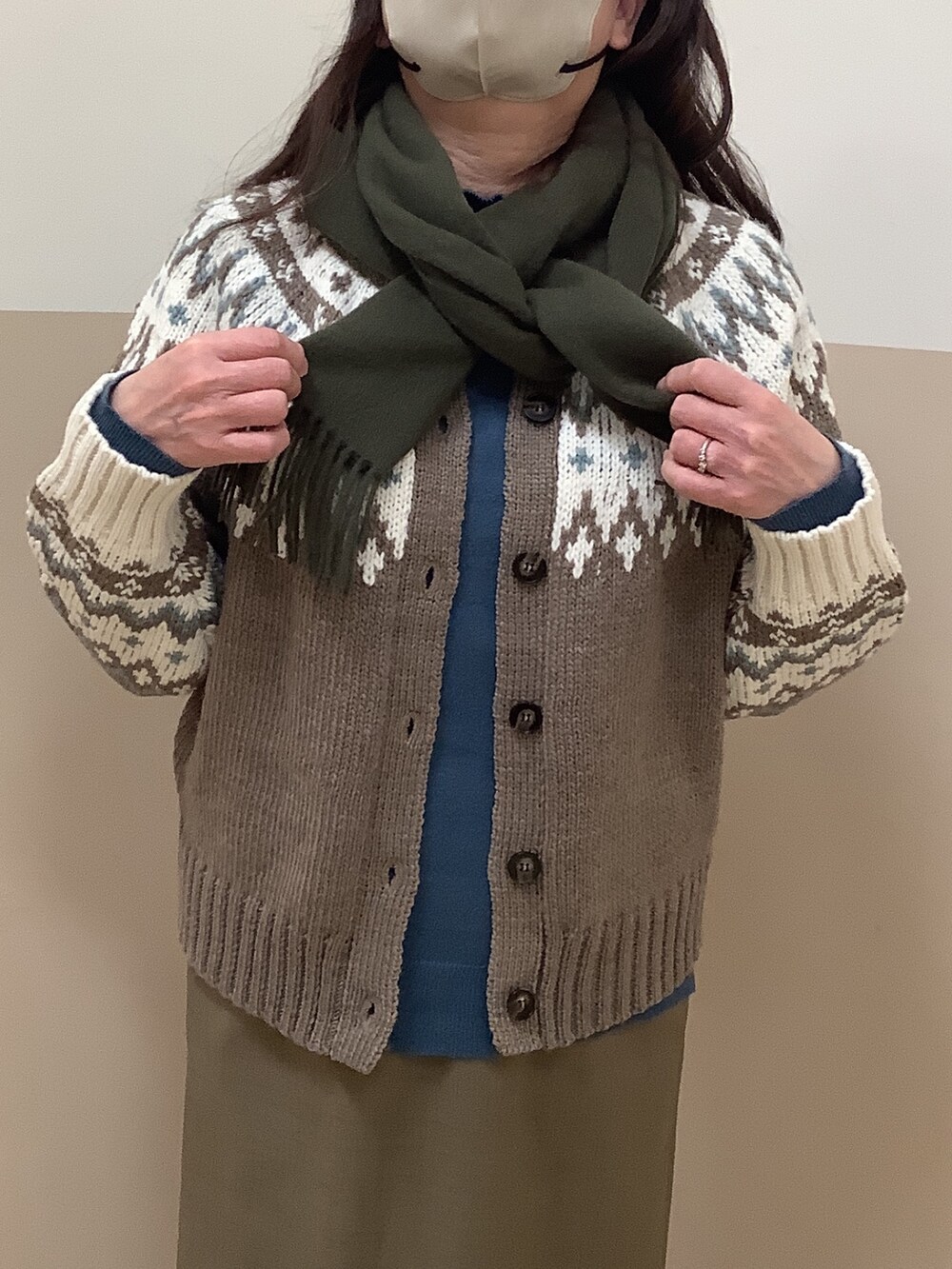 ブルー系のニット/セーター、ブラウン系のカーディガン/ボレロ、グリーン系のマフラーを着用したレディースの冬コーディネートの2枚目の写真