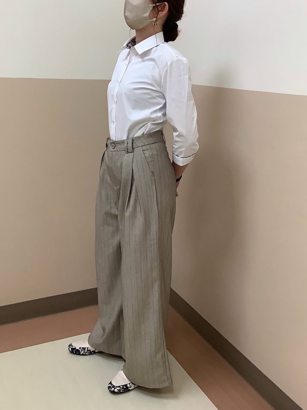 ホワイト系のビジネスシャツを着用したレディースの春コーディネートの3枚目の写真