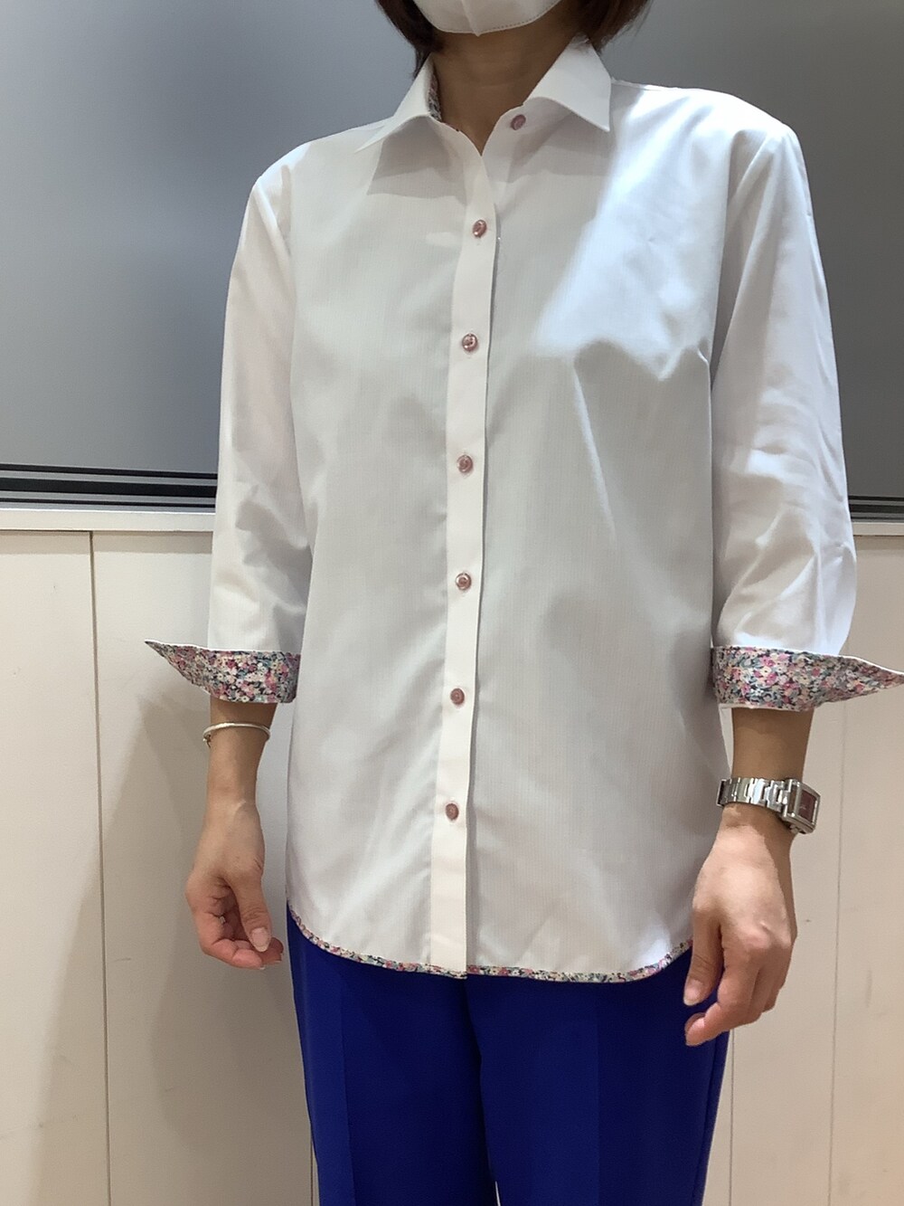 ホワイト系のビジネスシャツを着用したレディースの春コーディネートの2枚目の写真