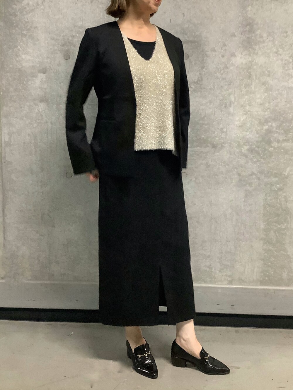 ゴールド系のニット/セーターを着用したレディースの秋コーディネートの2枚目の写真