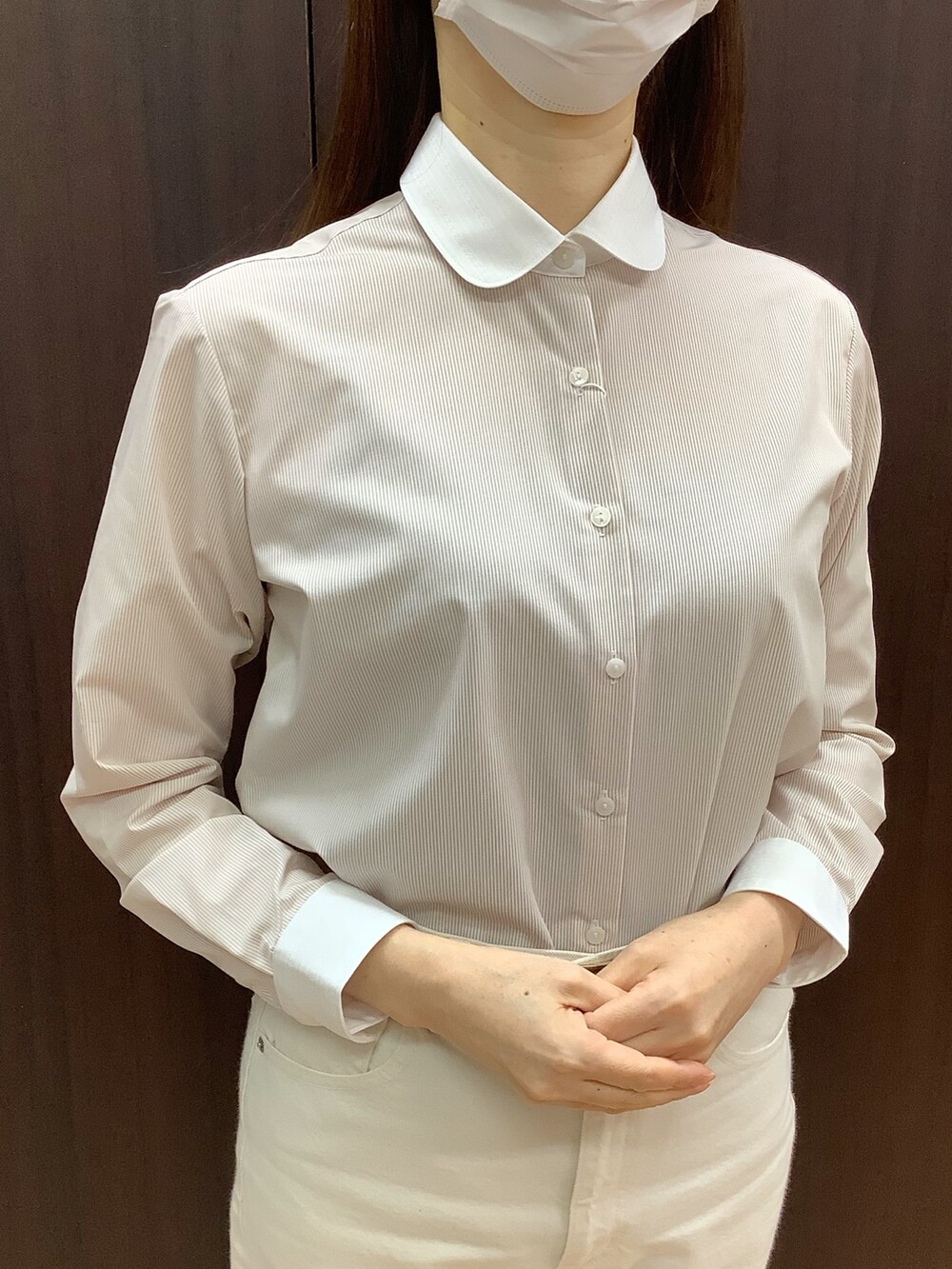 ベージュ系のビジネスシャツ、ブラック系のテーラードジャケットを着用したレディースの冬コーディネートの2枚目の写真