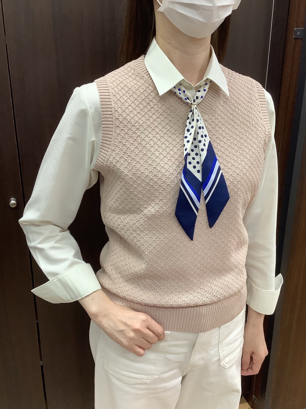 ピンク系のベスト、イエロー系のビジネスシャツ、ブルー系のバンダナ/スカーフを着用したレディースの冬コーディネートの2枚目の写真