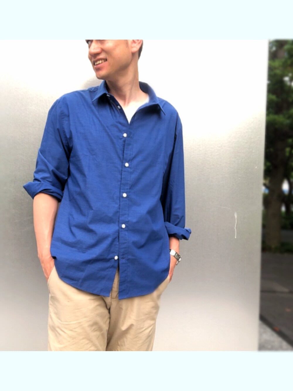 ベージュ系のスニーカー、ベージュ系のチノパンツ、ブルー系のシャツ/ブラウスを着用したメンズの夏コーディネートの3枚目の写真