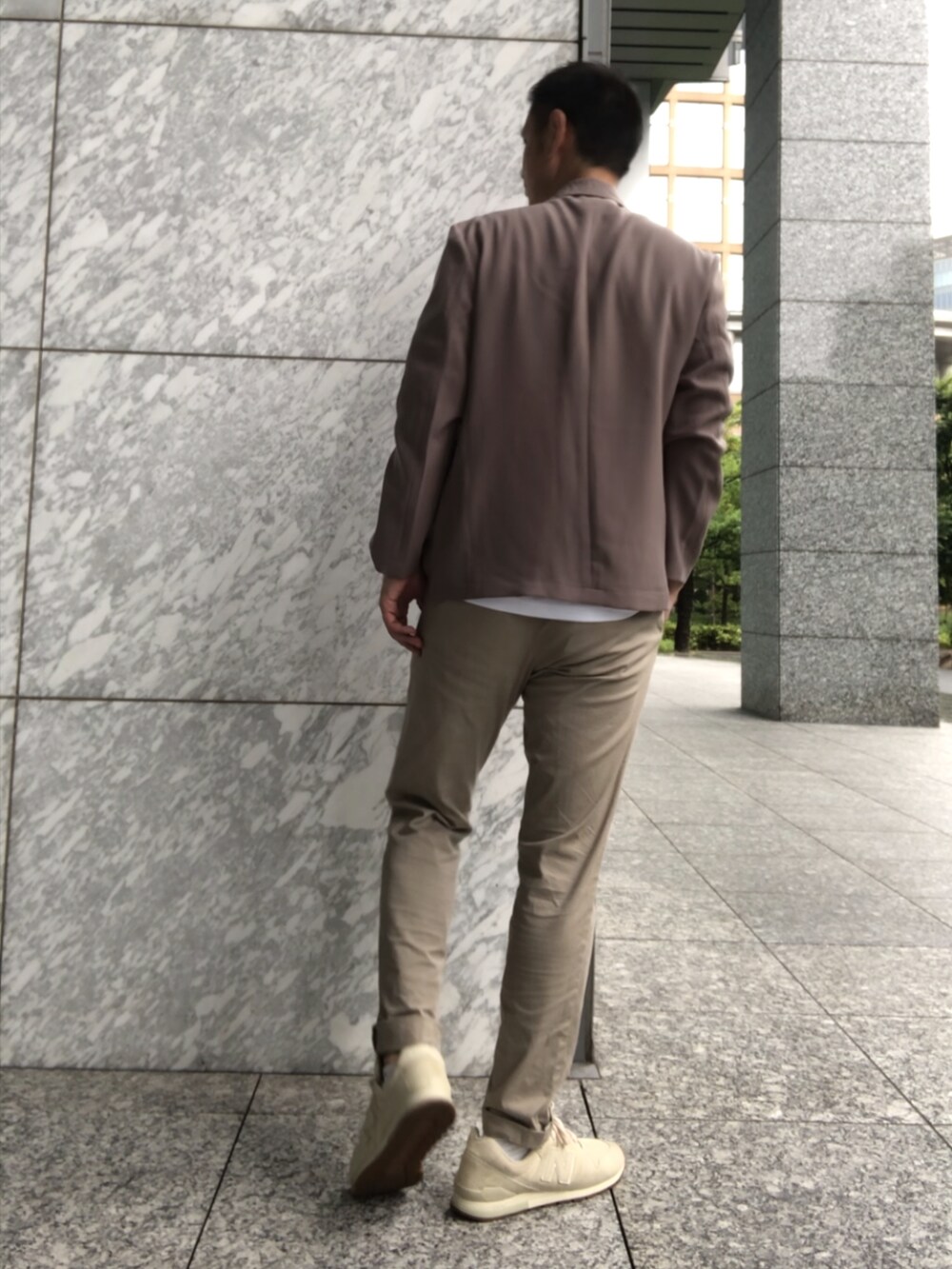 ブラック系のシャツ/ブラウス、ベージュ系のチノパンツ、ベージュ系のスニーカーを着用したメンズの夏コーディネートの3枚目の写真