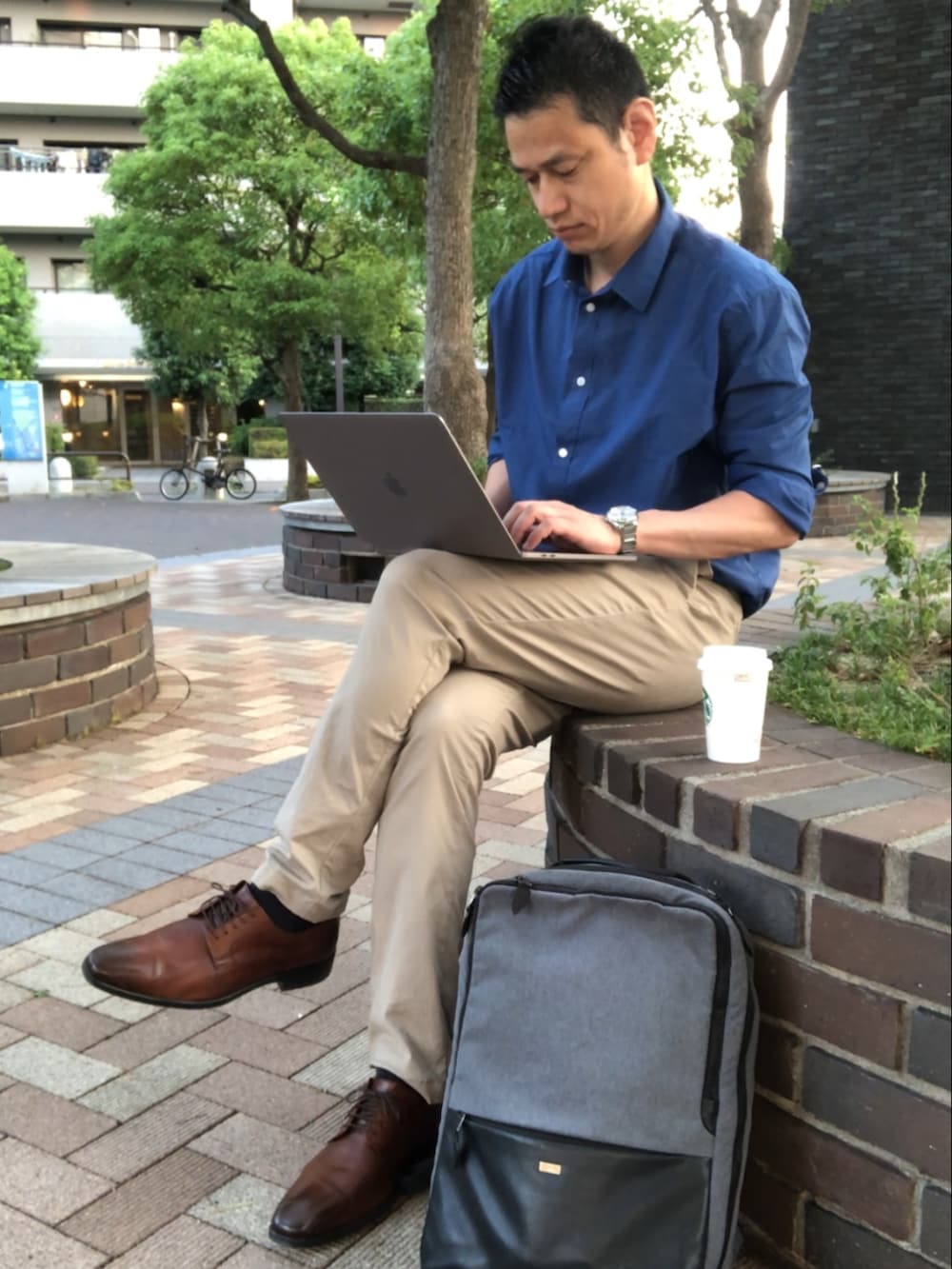 ベージュ系のチノパンツ、ブラウン系のドレスシューズ、ブルー系のシャツ/ブラウスを着用したメンズの夏コーディネートの3枚目の写真