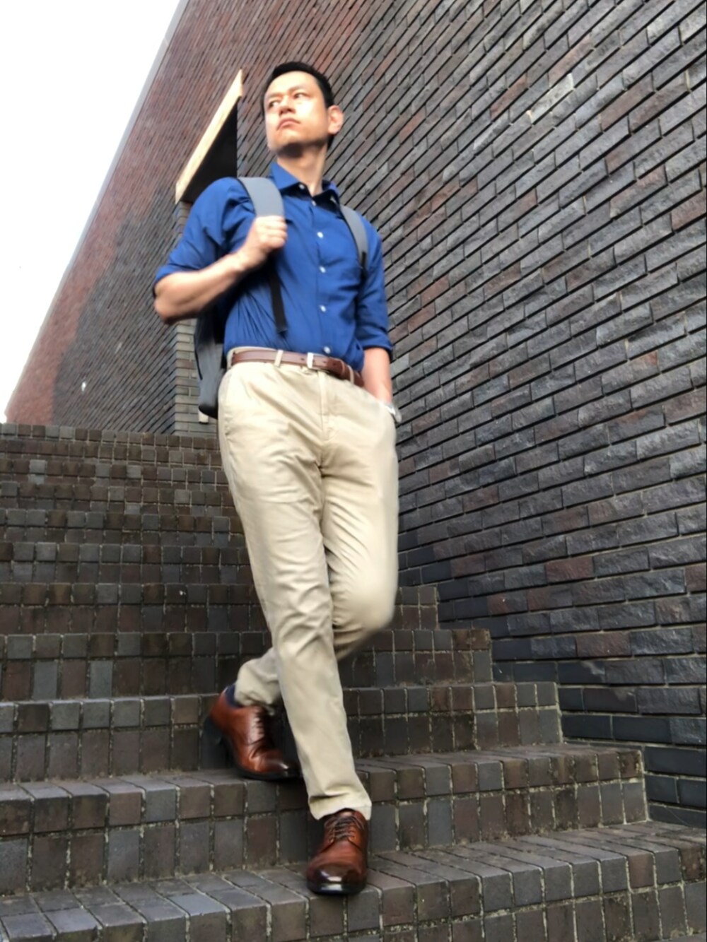 ベージュ系のチノパンツ、ブラウン系のドレスシューズ、ブルー系のシャツ/ブラウスを着用したメンズの夏コーディネートの2枚目の写真