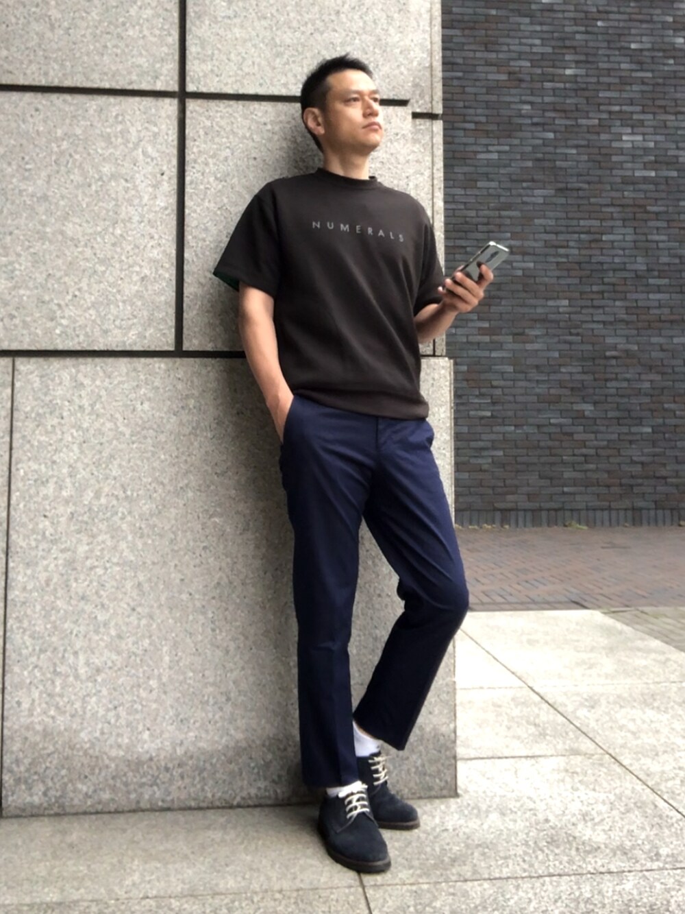 ブラック系のTシャツ/カットソー、ブラウン系のチノパンツ、ブルー系のドレスシューズを着用したメンズの夏コーディネートの4枚目の写真