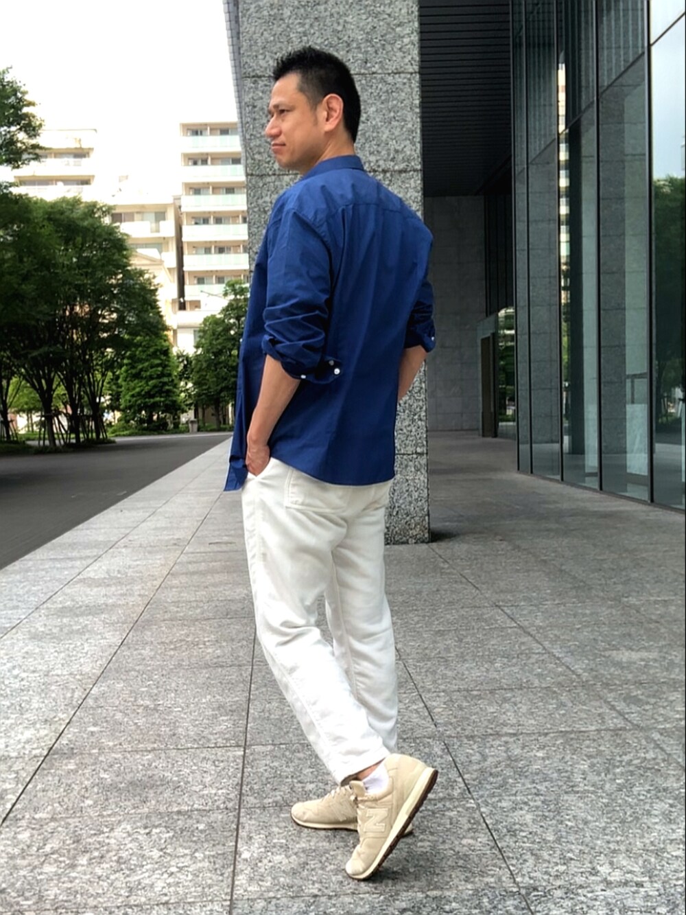 ホワイト系のチノパンツ、ブルー系のシャツ/ブラウス、ベージュ系のスニーカーを着用したメンズの夏コーディネートの3枚目の写真