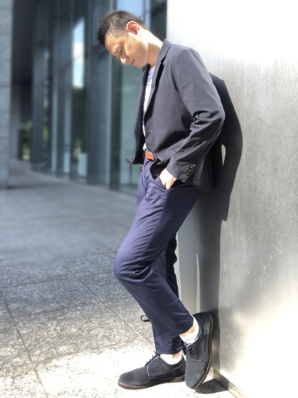 ブラウン系のドレスシューズ、ブルー系のチノパンツ、ホワイト系のTシャツ/カットソーを着用したメンズの夏コーディネートの2枚目の写真