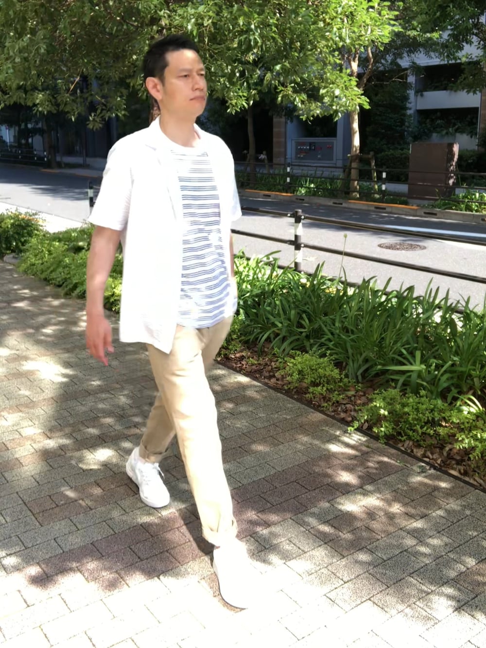 ベージュ系のチノパンツ、ホワイト系のスニーカー、ホワイト系のシャツ/ブラウスを着用したメンズの夏コーディネートの2枚目の写真