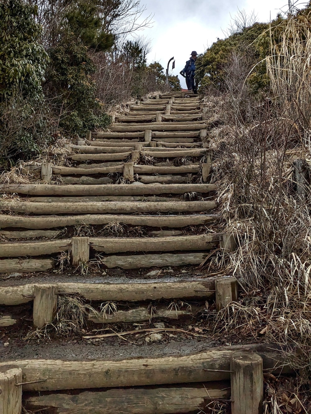 グリーン系のマウンテンパーカー、ブラック系のパンツ、ブラウン系のブーツを着用したメンズの春コーディネートの2枚目の写真