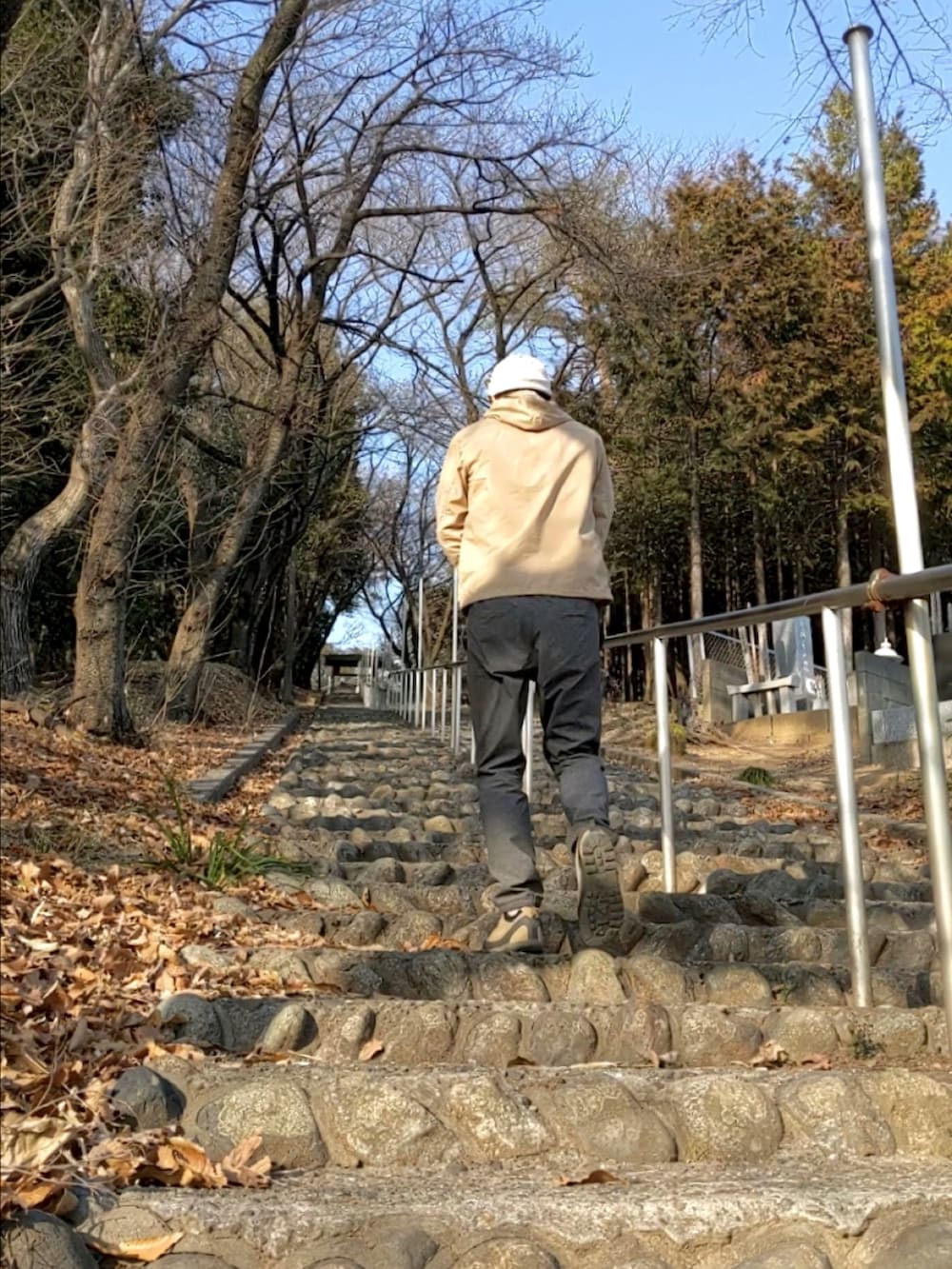 ベージュ系のマウンテンパーカー、ベージュ系のその他シューズ、グレー系のその他パンツを着用したメンズの春コーディネートの3枚目の写真